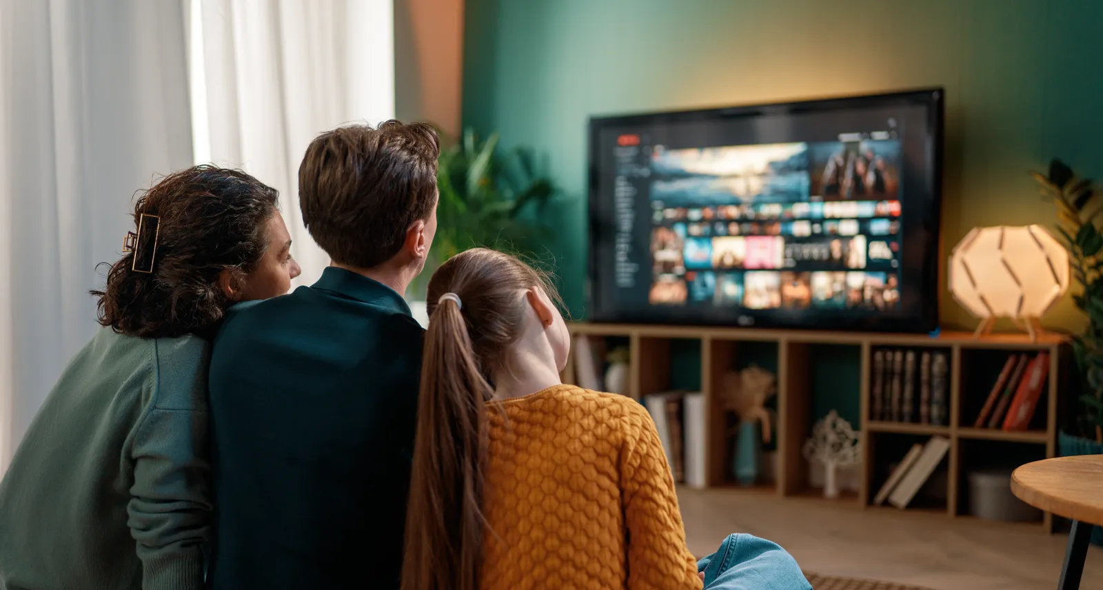 Family relaxing together and watching television at home, the audience for our streaming and VOD deliveries