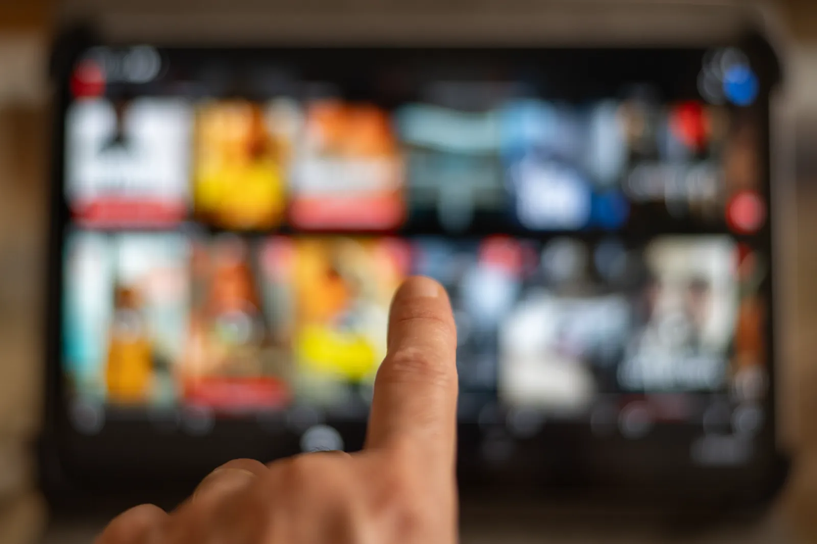 Hand selecting entertainment on a digital tablet, reflecting platform-ready broadcast deliveries